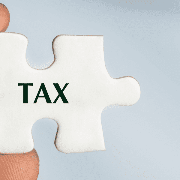 puzzla s nápisom tax držaná v prstoch