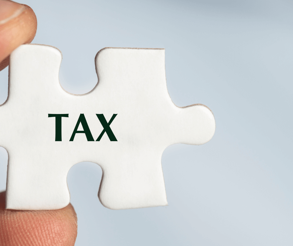 puzzla s nápisom tax držaná v prstoch